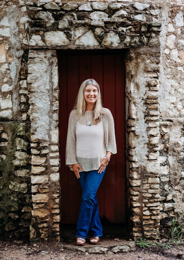 Lisa Wheeler smiling in a stone doorway
